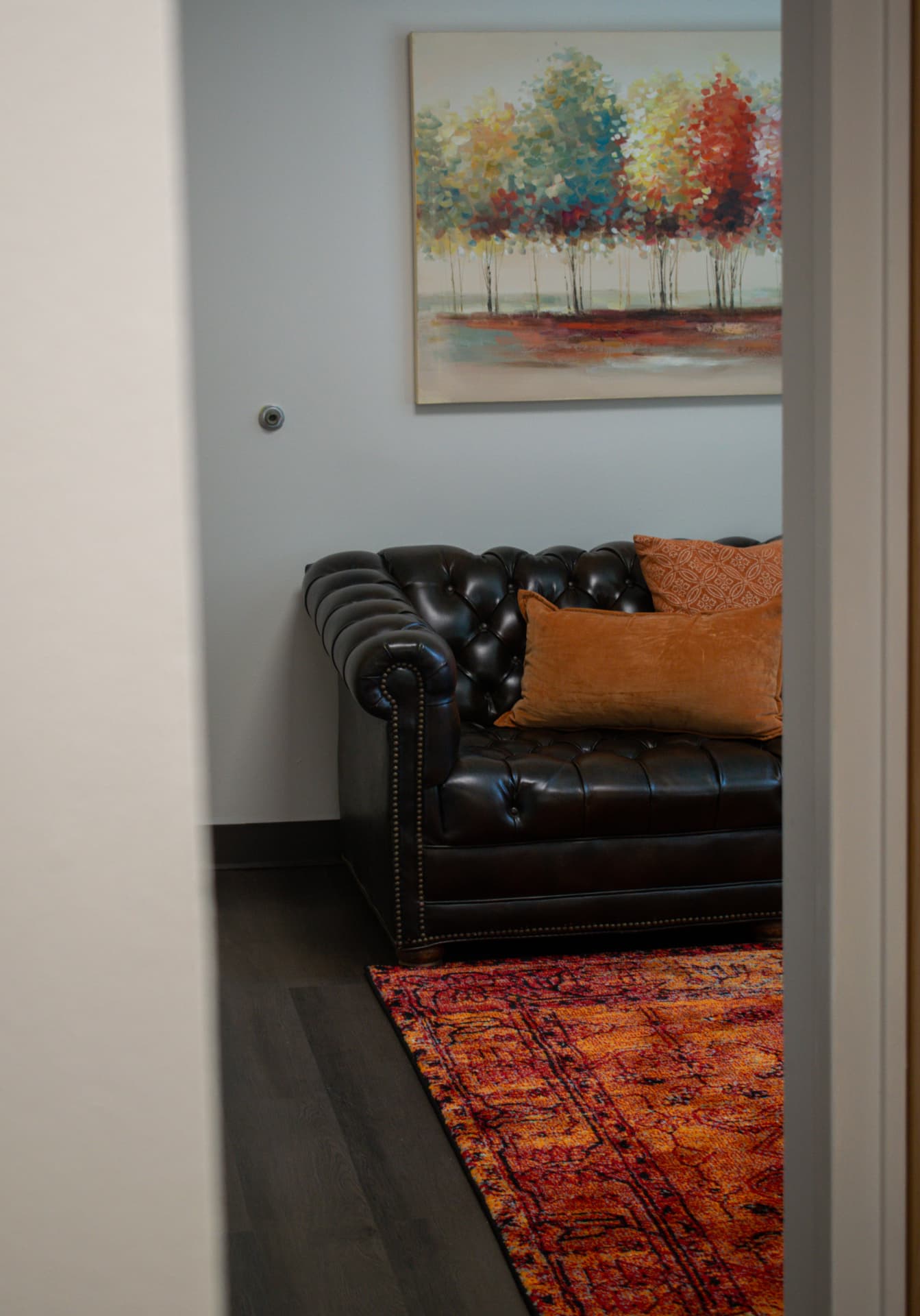 Warm waiting area with a leather sofa and colorful artwork at the YES clinic