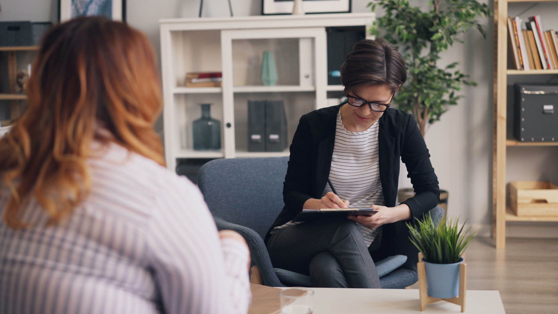 A psychologist taking notes during a confidential evaluation.
